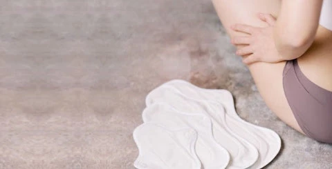 Cropped photo of a woman sitting beside various sizes of hannahpads