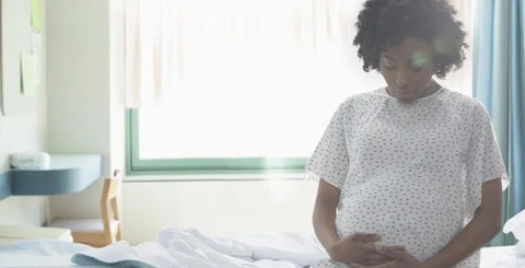 Black mother sitting on a hospital bed