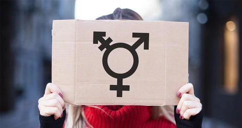 Woman holding up the transgender symbol