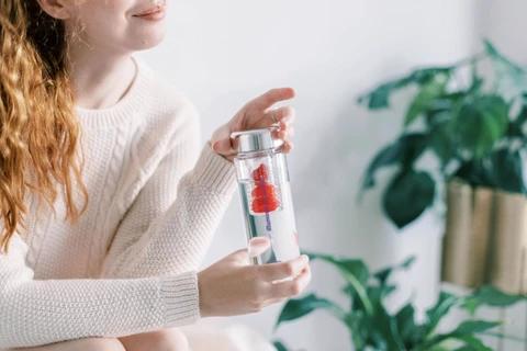 woman holding illum water bottle