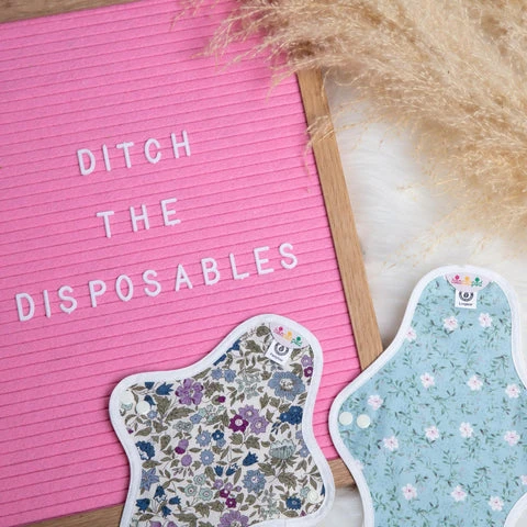Close up of some hannahpads and a sign that reads “ditch the disposables”