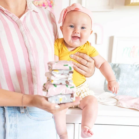 Close up of Alyssa Garrison holding her baby and a stack of hannahpads